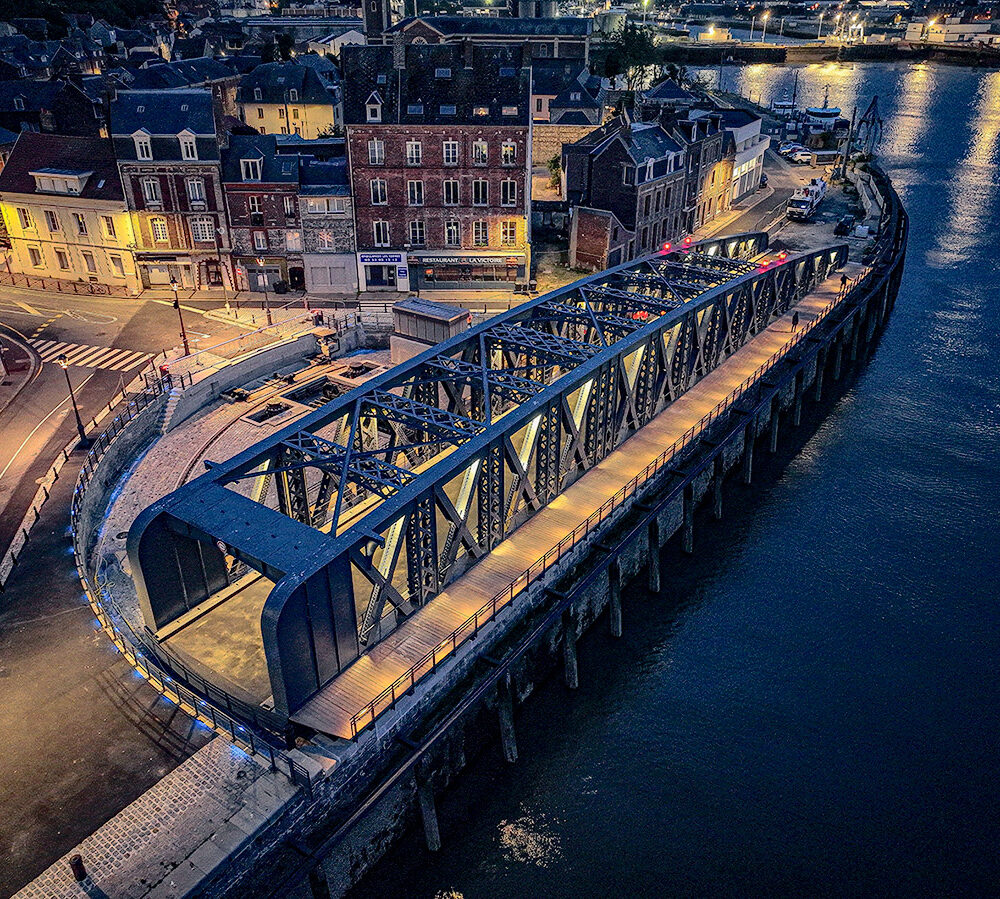 Le pont Colbert de Dieppe éclairé, vu de haut, à la tombée de la nuit