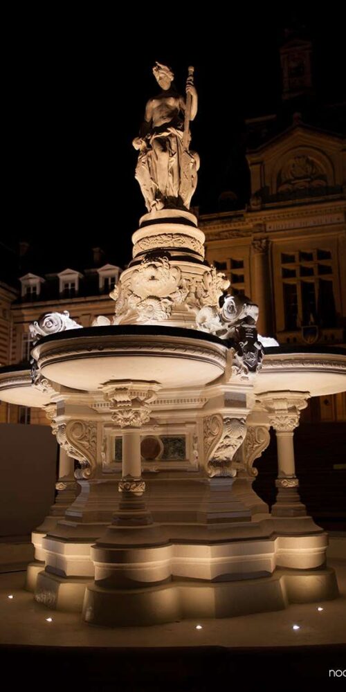Fontaine illuminée devant l’hôtel de ville d’Évreux, la nuit