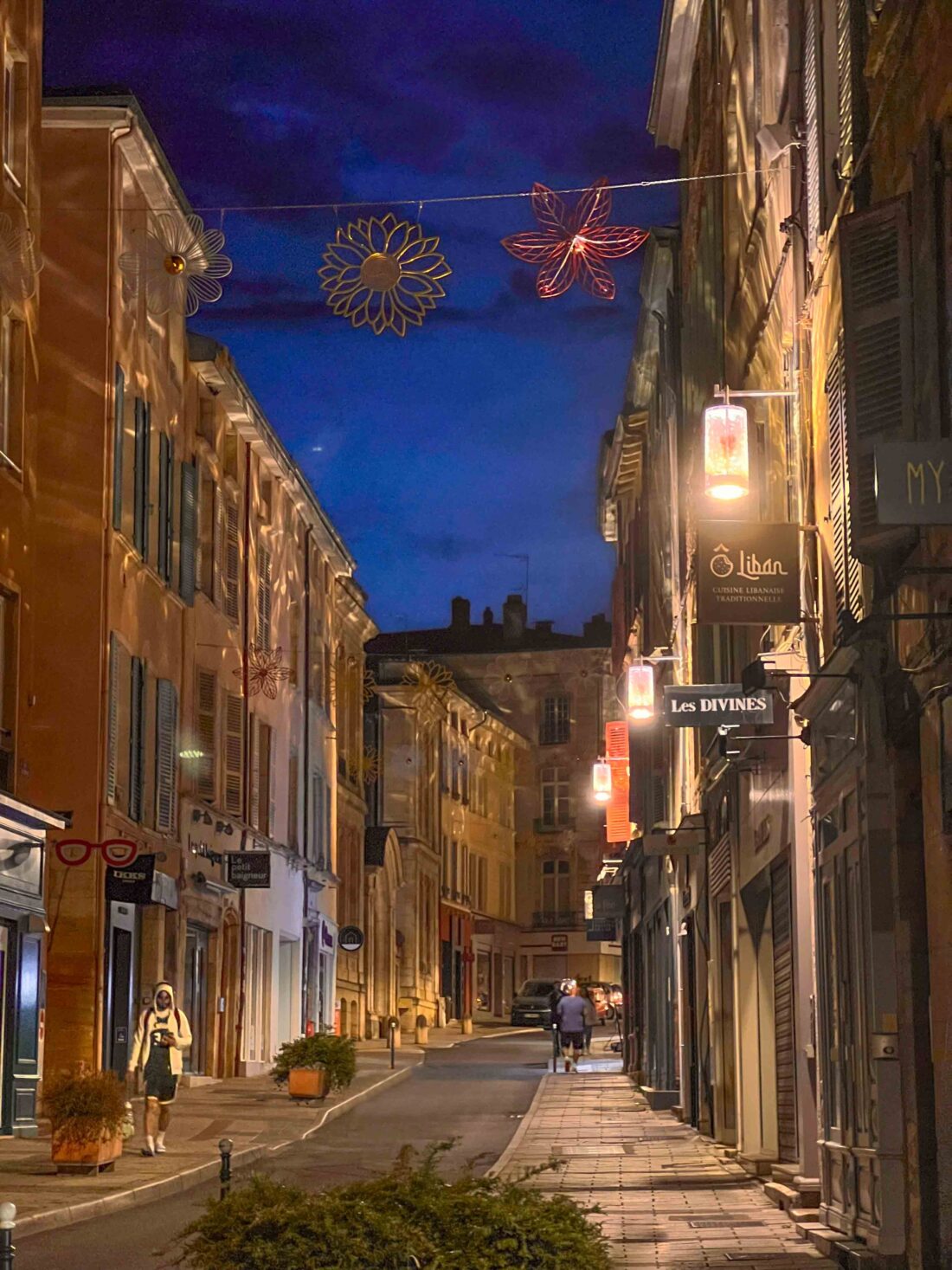 Rue commerçante de Mâcon éclairée par les lanternes Leiza